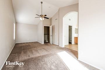 Peoria house for rent - a spacious living room with carpet and a ceiling fan