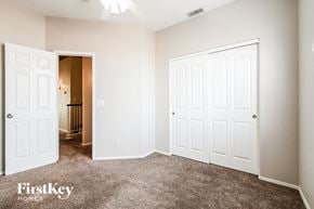 Peoria house for rent - a bedroom with two closets and a carpeted floor