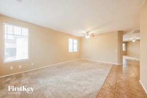 Goodyear house for rent - a empty living room with a ceiling fan and a large window