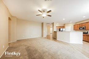 Goodyear house for rent - an empty living room and kitchen with a ceiling fan