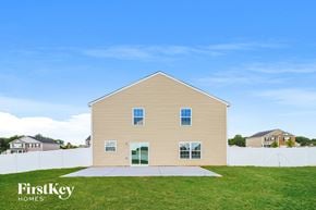 Lexington house for rent - a yellow house with a grassy yard and a white fence