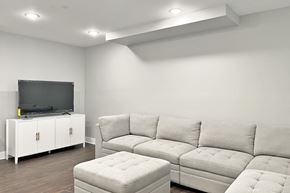 Oak Park apartment for rent - A white couch and ottoman are in a room with a television on a cabinet.