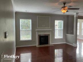 Indian Trail house for rent - A living room with a fireplace and a ceiling fan.