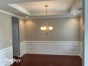 Indian Trail house for rent - A chandelier hangs over a white panelled wall in a room.