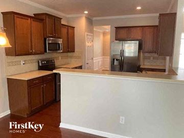 Indian Trail house for rent - A kitchen with wooden cabinets and a refrigerator.