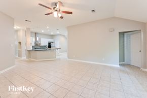 Houston house for rent - A spacious living room with a fan and tiled floor.