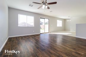 Buckeye house for rent - an empty living room with wood floors and a ceiling fan