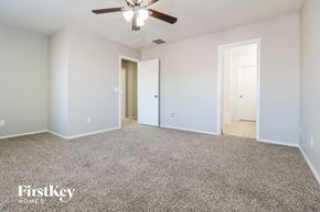 Buckeye house for rent - a bedroom with a carpeted floor and a ceiling fan