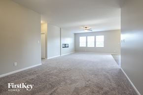 Indianapolis house for rent - an empty living room with carpet and a ceiling fan