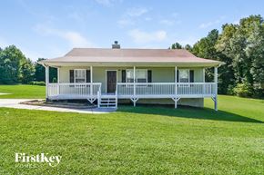 Temple house for rent - a small yellow house with a white porch and a lawn