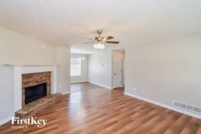 Temple house for rent - a living room with a fireplace and a ceiling fan