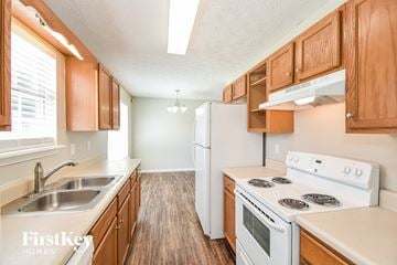 Temple house for rent - a kitchen with wood flooring and white appliances and wooden cabinets