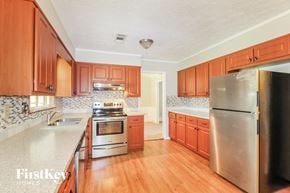 Lawrenceville house for rent - a kitchen with wooden cabinets and stainless steel appliances
