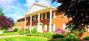 North Muskegon apartment for rent - A red brick house with white columns and a white door.