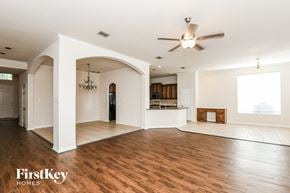 Fort Worth house for rent - A spacious living room with a ceiling fan and hardwood floors.