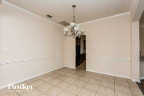 Fort Worth house for rent - A spacious room with a chandelier and tiled flooring.