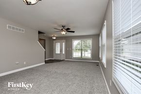 O'fallon house for rent - an empty living room with a ceiling fan and large windows