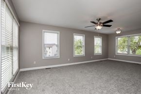O'fallon house for rent - an empty living room with a ceiling fan and three windows