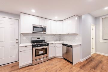 Chicago apartment for rent - a kitchen with white cabinets and stainless steel appliances