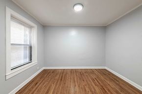 Chicago apartment for rent - an empty living room with a window and wooden floors