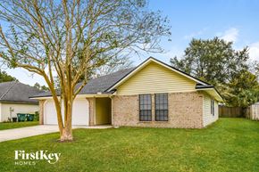 Jacksonville house for rent - the front of a yellow house with a tree in the yard