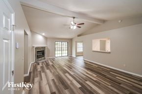Jacksonville house for rent - an empty living room with a fireplace and a ceiling fan
