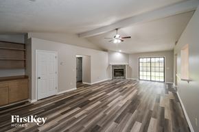 Jacksonville house for rent - an empty living room with a fireplace and a ceiling fan