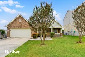 San Antonio house for rent - A house with a garage and a tree in front of it.