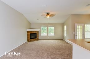 San Antonio house for rent - A spacious living room with a fireplace and a ceiling fan.