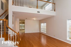 San Antonio house for rent - A spacious living room with wooden floors and a staircase leading to the upper level.