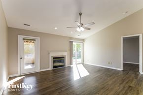 Noblesville house for rent - A spacious room with a fireplace and a ceiling fan.