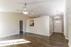 Noblesville house for rent - A spacious room with a ceiling fan and hardwood floors.