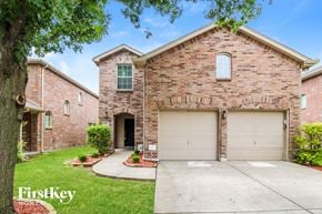 Mckinney house for rent - a brick house with a garage door and a driveway