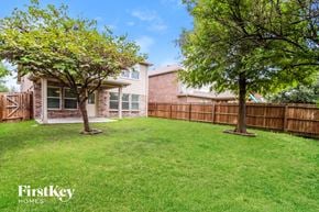 Mckinney house for rent - a backyard with two trees and a fence