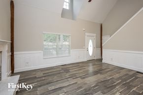Gainesville house for rent - the living room with wood floors and white walls and a white door