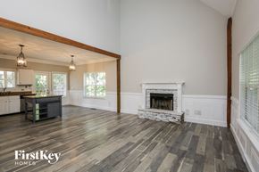 Gainesville house for rent - an open living room with a fireplace and a kitchen
