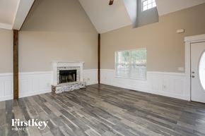 Gainesville house for rent - the living room of a home with a fireplace and wooden floors