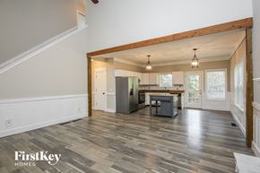 Gainesville house for rent - an open kitchen and living room with white walls and wood floors