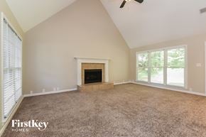 Woodstock house for rent - A spacious room with a fireplace and a ceiling fan.