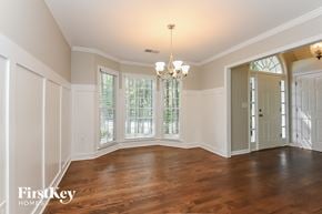 Woodstock house for rent - A large empty room with wooden floors and a chandelier.
