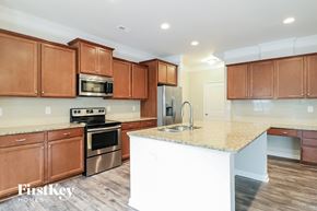 Clayton house for rent - a kitchen with wooden cabinets and a marble counter top