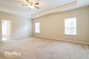 Clayton house for rent - a master bedroom with carpet and a ceiling fan