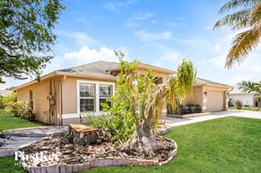 Lehigh Acres house for rent - a house with a palm tree in the front yard