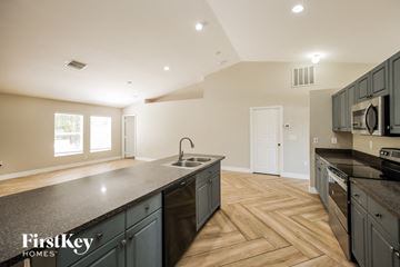 Lehigh Acres house for rent - a kitchen with an island and a stove and a sink