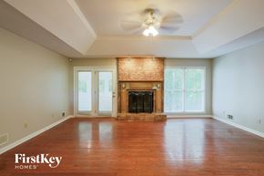 Stockbridge house for rent - an empty living room with a fireplace and a ceiling fan
