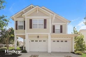 Charlotte house for rent - a white house with two garage doors in front of it