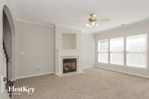 Charlotte house for rent - a living room with a fireplace and a ceiling fan