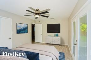 San Antonio house for rent - A bedroom with a bed, dresser, and a ceiling fan.