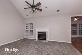 Indian Trail house for rent - a living room with a fireplace and a ceiling fan