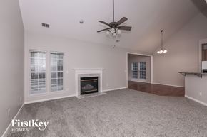 Indian Trail house for rent - a living room with a fireplace and a ceiling fan